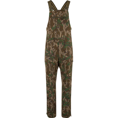 Camo-patterned Turkey Bib with Spider Web Technology on mannequin, featuring adjustable straps, front zip pocket, side cargo pockets, and ankle zippers, designed for hunting durability and comfort.