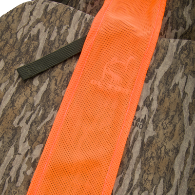 Turkey Strap Vest with camouflage fabric, featuring high-visibility orange mesh, olive webbing strap, and multiple gear pockets for efficient turkey hunting.
