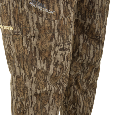Close-up of Ol' Tom Early Bird SWT Pant showing Mossy Oak Bottomland camo pattern and embroidered Vital Protection® logo, highlighting its insect-repellent and durable features.