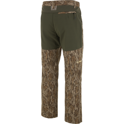 Ol' Tom Early Bird SWT Pant in woodland camo with olive stretch waistband, designed for hunters with insect-repellent, water-resistant fabric, and practical gear pockets.