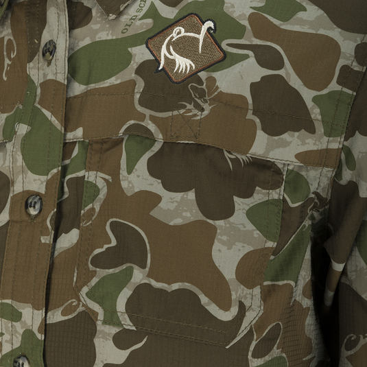 A close-up of the Ol' Tom Youth Mesh Back Flyweight Shirt 2.0, featuring a camouflage pattern.