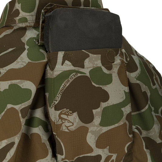 A close-up of the Women's Mesh Back Flyweight Shirt 2.0, a camouflage jacket with a black object in the pocket.