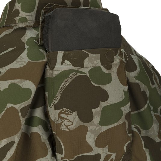 A close-up of the Youth Mesh Back Flyweight Shirt 2.0, a camouflage jacket with a black pocket.