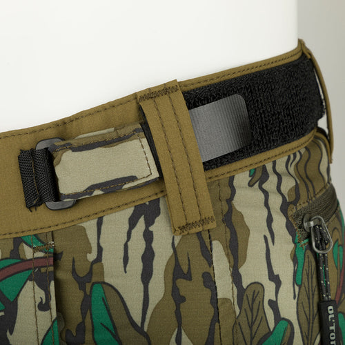 A close-up of the Women's Tech Stretch Turkey Pant, featuring reinforced knees, ankles, and bottom. Designed for spring turkey hunting, it offers a relaxed fit, gusseted crotch, and mesh pockets for ventilation. Perfect for slipping through the woods or remaining concealed during long waits.
