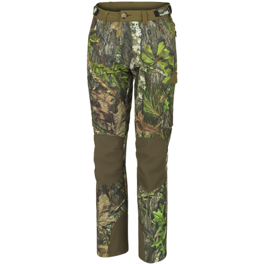 A pair of Women's Tech Stretch Turkey Pants, designed for spring turkey hunting. Lightweight, moisture-wicking, and abrasion-resistant with 4-way stretch technology. Features reinforced knees, ankles, and bottom, gusseted crotch for comfort, relaxed fit, adjustable waistband, mesh pockets, zippered back pockets, and cargo pockets. Ideal for slipping through the woods or remaining concealed during long waits.