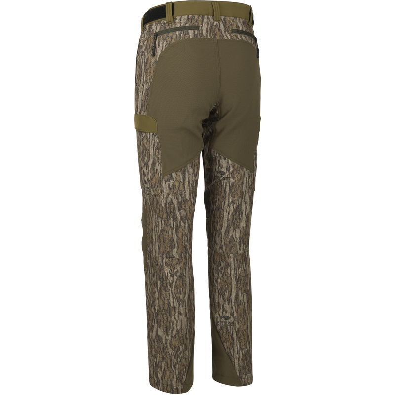 A close-up of the Women's Tech Stretch Turkey Pant, featuring a camouflage fabric. Designed for spring turkey hunting, these lightweight, moisture-wicking pants have reinforced knees and ankles, a gusseted crotch, and a relaxed fit for comfort.