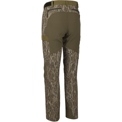 A close-up of the Women's Tech Stretch Turkey Pant, featuring a camouflage fabric. Designed for spring turkey hunting, these lightweight, moisture-wicking pants have reinforced knees and ankles, a gusseted crotch, and a relaxed fit for comfort.