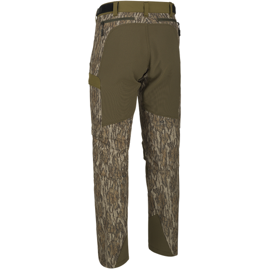 A close-up of the Youth Tech Stretch Turkey Pant, a pair of camouflage pants with reinforced knees, ankles, and bottom. Designed for comfort and durability, these pants feature a gusseted crotch and adjustable waistband. Mesh and zippered pockets provide ventilation and storage. Perfect for hunting and outdoor activities.