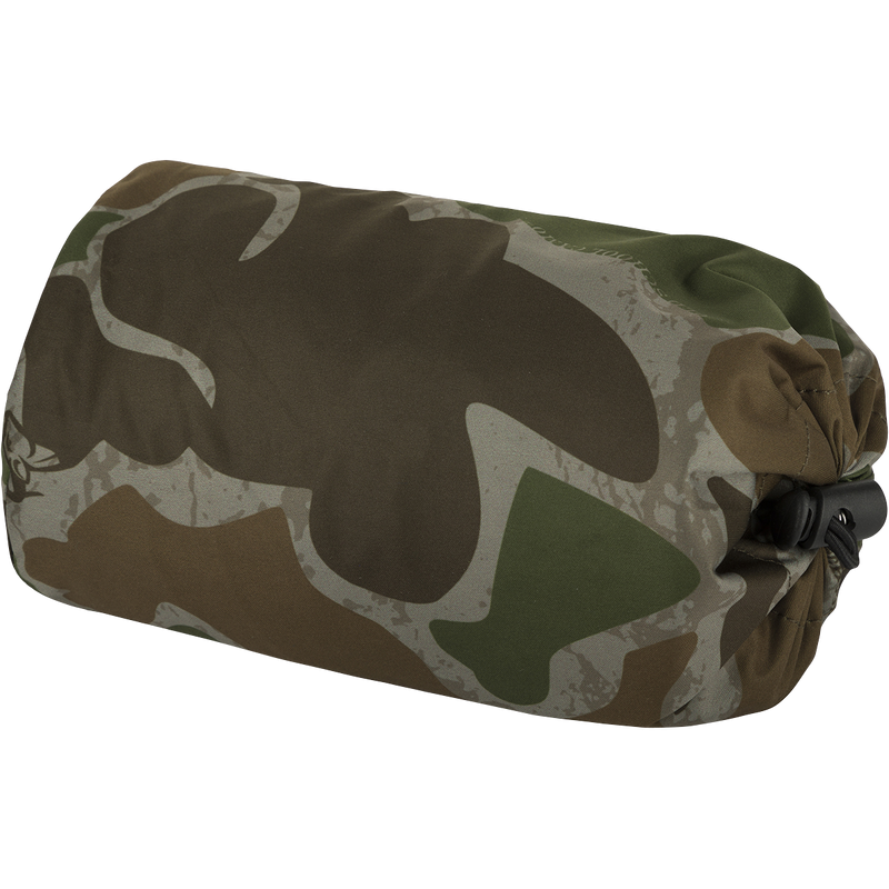 Ultralight Packable Rain Pant - A camouflage bag with a black strap and a close-up of a camouflage fabric. Waterproof and windproof, perfect for spring showers during turkey season. Fits easily in your vest.