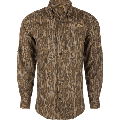 Ol' Tom Men's Camo Wingshooter Trey Shirt in Bottomland camouflage, featuring two chest pockets, a pointed collar, and embroidered branding on a mannequin against a white background.