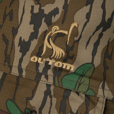 Men's Camo Wingshooter Trey Shirt, featuring a camouflage pattern fabric with two chest pockets and hidden button-down collar, designed for performance and comfort.