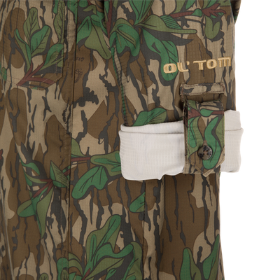Men's Camo Wingshooter Trey Shirt with camouflage pattern, featuring button-through flap chest pockets and vented cape back, designed for performance and comfort in outdoor settings.