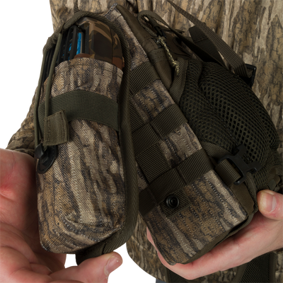 Turkey Chest Pack held by a person, featuring a lightweight design with multiple pockets, loops, a detachable bino harness, and a stowable rain fly.