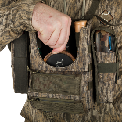 Turkey Chest Pack held by person, showcasing its multiple pockets, straps, and compact design, ideal for hunting trips with a detachable bino harness.