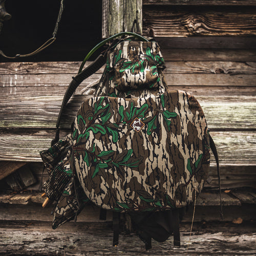 Time & Motion™ Gunslinger Turkey Vest - A camouflage backpack with multiple pockets for calls and gear, featuring a cushioned backrest and adjustable shoulder straps.