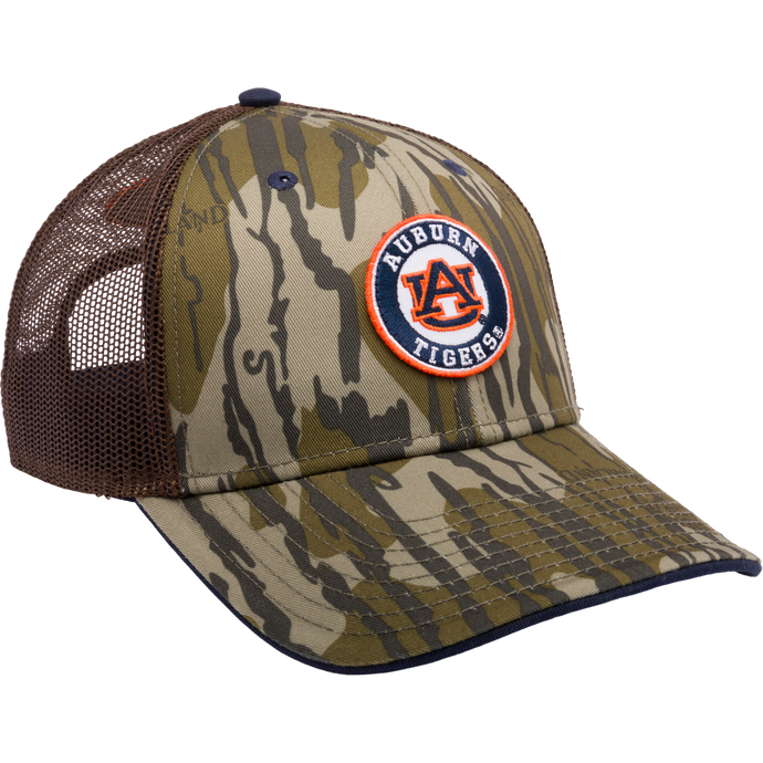 Auburn Bottomland Mesh Back Cap featuring Mossy Oak Bottomland Camo pattern. 6-panel trucker cap with embroidered college logo, X-Peak visor, and adjustable snap-back closure. Ideal for hunting and outdoor enthusiasts.