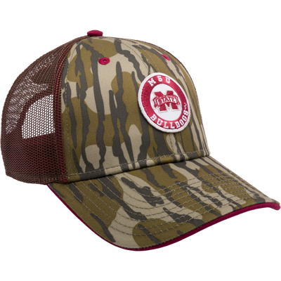 A Mississippi State Bottomland Mesh Back Cap featuring Mossy Oak Bottomland Camo pattern. Structured with poly twill front, mesh back, X-Peak visor, and 3D embroidered college logo. Snap-back closure.