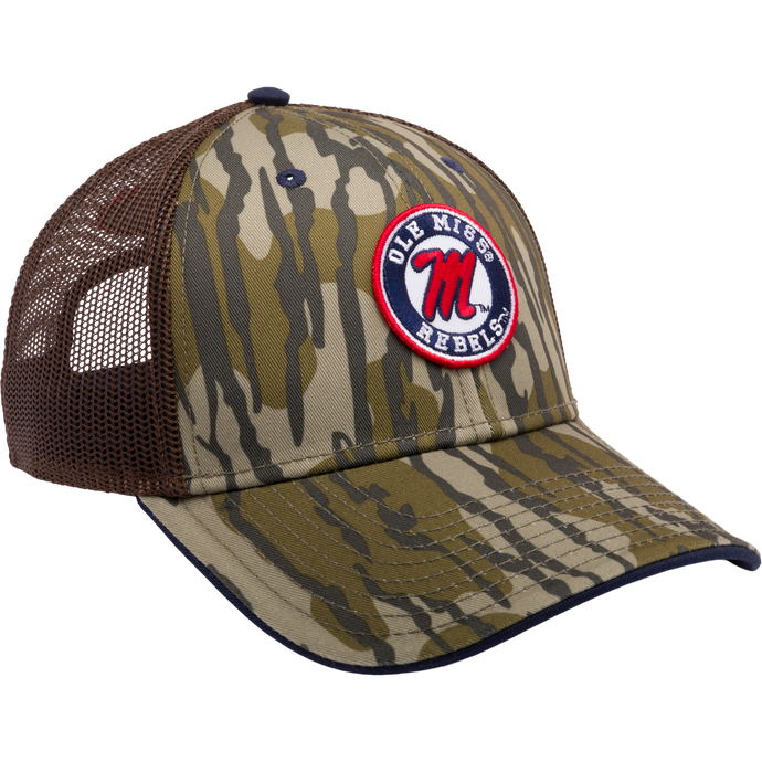 Alt text: Ole Miss Bottomland Mesh Back Cap featuring Mossy Oak Bottomland Camo pattern, 6-panel construction with mesh back, X-Peak visor, and embroidered college logo. Snap-back closure for adjustability.