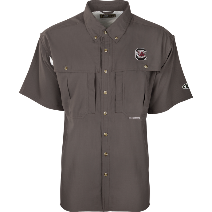 South Carolina S/S Flyweight Wingshooter: A grey shirt with a logo, designed for warm-weather outdoor activities. Features include vented back design, quick-drying fabric, UPF 50+ sun protection, and multiple pockets.