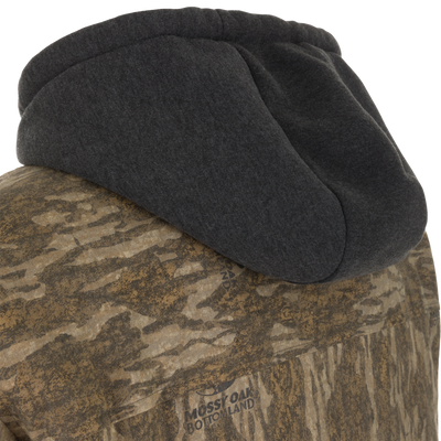 Close-up of a Spoonie Campfire Hoodie featuring a dark grey hood and a camouflage-patterned body with Mossy Oak Bottomland text printed on the back.