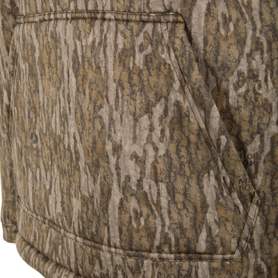 Close-up of a Spoonie Silencer Hoodie, a heavyweight fleece garment featuring a brown and tan tree bark camouflage pattern and a large front kangaroo pocket.