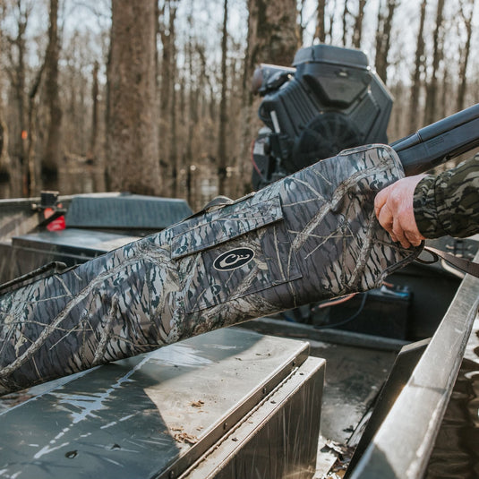 A side-opening gun case by Drake Waterfowl, designed for shotguns up to 52 long. Features a hook and loop flap for easy access, rugged HD2™ exterior, nylon interior, and an outer pocket for choke tubes.