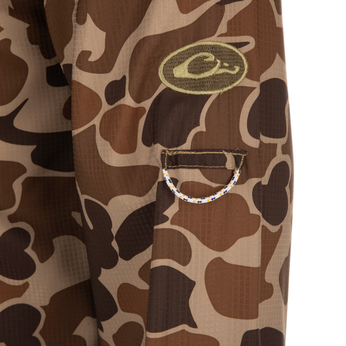 A close-up of the Drake 8-Shot Flyweight L/S Shirt, featuring a camouflage pattern and hidden pockets. 