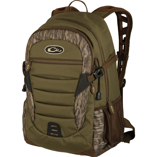 A Drake Daypack, a green backpack with brown straps, perfect for storing essential items in a more compact design. Features large zippered storage area, hydration pouch pocket, EVA shoulder straps, and more. Available in Small and Large sizes.