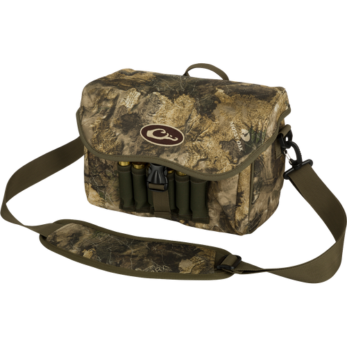 Refuge Blind Bag by Drake Waterfowl: Camouflage bag with gun case, ammo, and logo. Adjustable strap, durable hardware, outer pocket, shell loops, and waterproof lining. Ideal for daily waterfowl hunting.