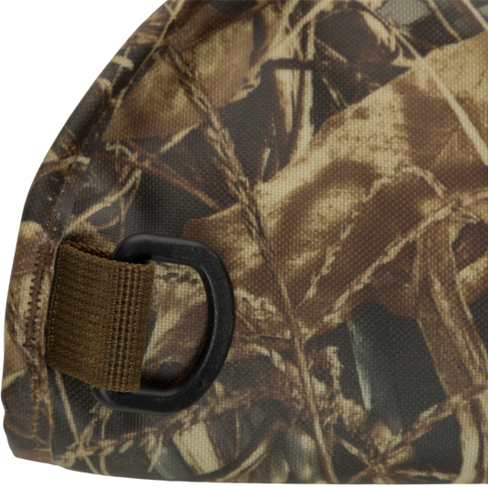 HND Shotgun Case: A close-up of a khaki camouflage bag with a belt buckle. Made with durable 600D Polyester and water-resistant protection. Convenient and easy to carry with an adjustable shoulder strap and D-Ring. Perfect for hunters.