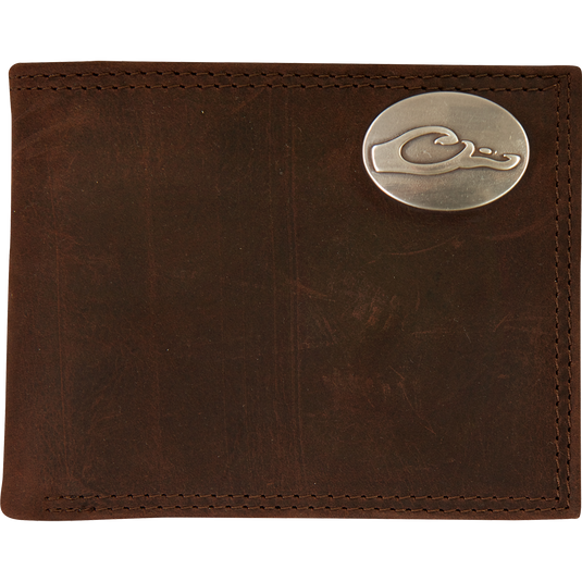 A Leather Bi-Fold Wallet featuring a brown full grain leather exterior and a silver oval Drake logo.