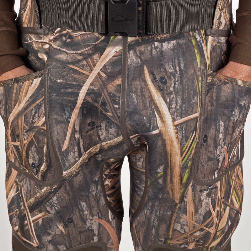 A person wearing Buckshot Eqwader 1600 Neoprene Wader 3.0 in camouflage shorts, with a logo on the surface and a black buckle on the fabric.