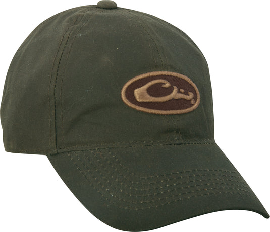 A mid-profile, six-panel Box Waxed Canvas Cap with a green logo patch on the front. Self fabric closure with brass slide adjustment.