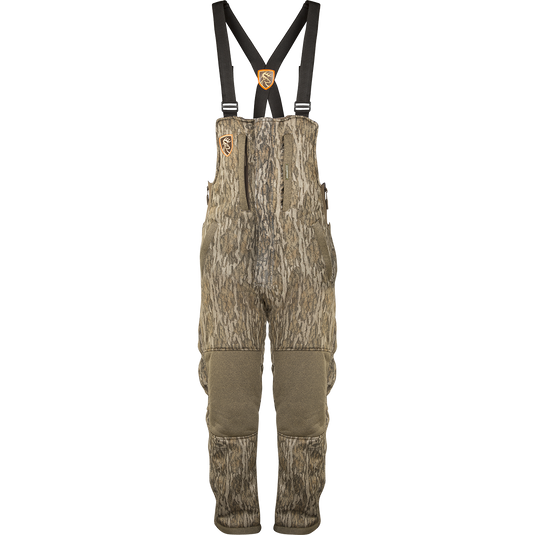A youth silencer bib with Agion Active XL technology, featuring camouflage overalls with suspenders and vertical pockets for hunting gear.