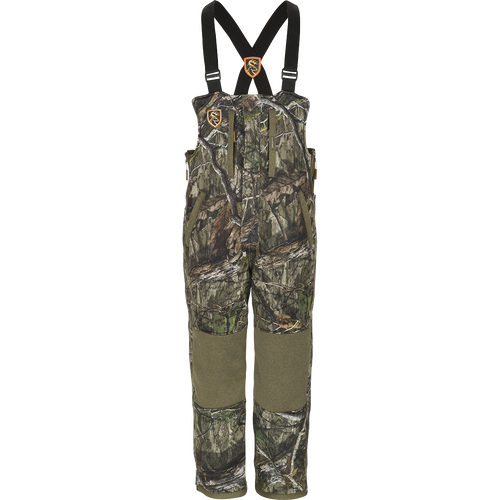 Youth Silencer Bib With Agion Active XL, a camouflage overalls with straps and vertical pockets for hunting gear.