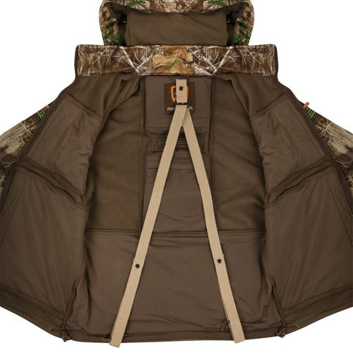 A mid-weight jacket for hunters, featuring a camouflage pattern and strap. Made with high gauge stretch interlock fabric and 200-gram Poly-Fleece backing. Includes scent control technology, multiple pockets, safety harness pass-through, and removable fleece-lined hood. Perfect for avid hunters.