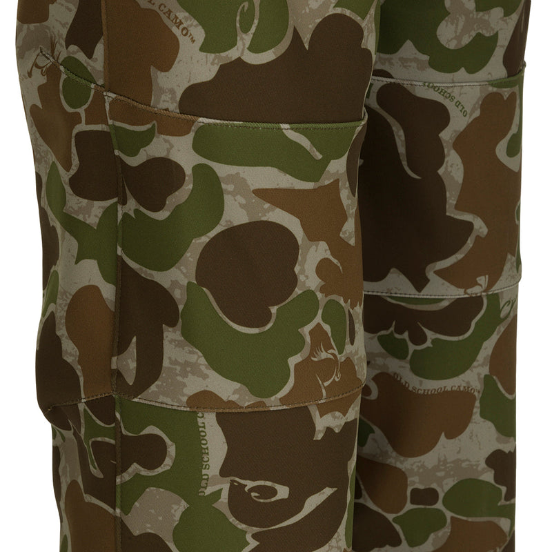 A pair of Pursuit Tech Stretch Pants with Agion Active XL®, featuring a camouflage pattern for lightweight early-mid season big game hunting. Made of durable 100% polyester bonded fleece fabric with 4-way stretch. Zippered pockets and hip vents for convenience and comfort.