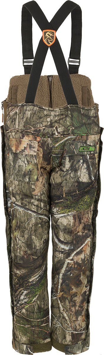 A pair of camouflage bibs with Agion Active XL scent control technology, vertical pockets for hunting gear, and a soft, durable fabric. Youth Silencer Bib with Agion Active XL.