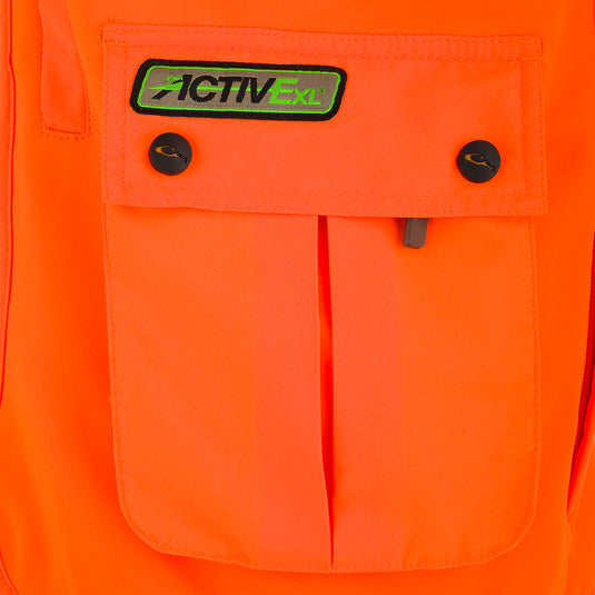 A close-up of a youth blaze orange vest with a pocket and logo. Equipped with storage pockets and a game bag for supplies in the field.