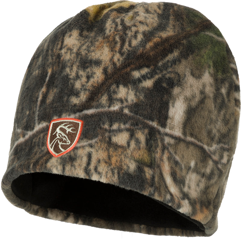 A Non-Typical Camo Windproof Fleece Beanie, featuring a logo, is shown in this image. The deep-cut design provides ear coverage.