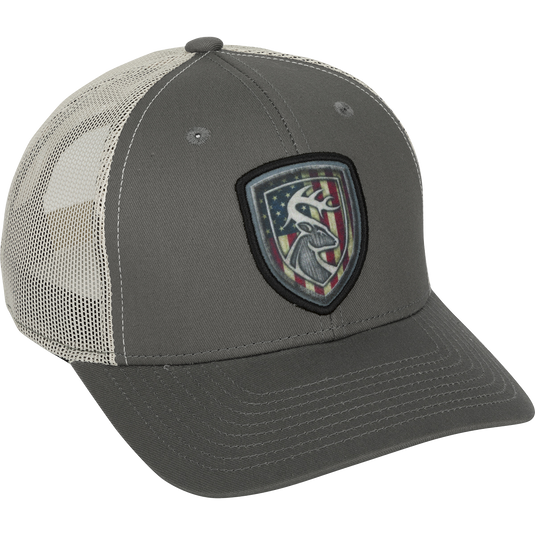 A grey baseball cap with a patch featuring a deer and flag. Made of 100% cotton twill and breathable mesh on the back. Adjustable snap closure.