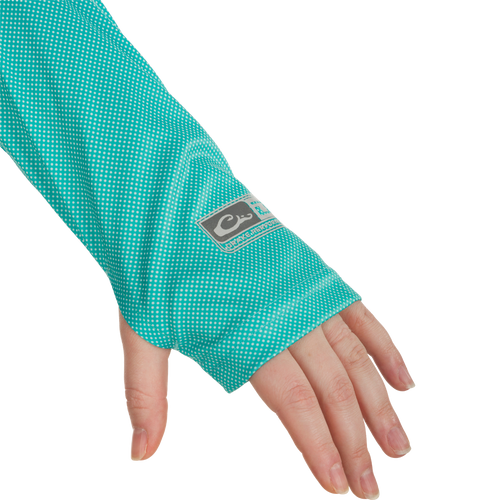 A hand wearing the Women's Performance Ombre Dot Crew, showcasing its green and white dotted sleeve.