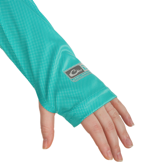 A hand wearing the Women's Performance Ombre Dot Crew, showcasing its green and white dotted sleeve.