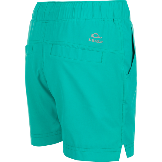 A pair of women's Commando Lined Shorts with a logo on the side, featuring clean lines, scalloped hem, and multiple pockets. 7" inseam, 4-way stretch, moisture-wicking, quick-drying, and water-resistant. Perfect for gym or beach.