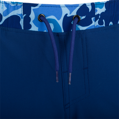 A close-up of the Youth Commando Lined Volley Short 5 with a blue fabric and zipper details.