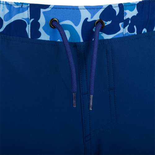 A close-up of the Youth Commando Lined Volley Short 5 with a blue fabric and zipper details.