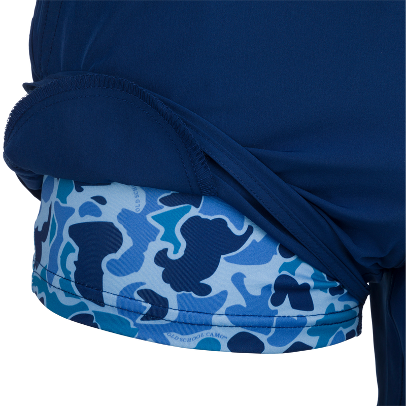 A person wearing the Youth Commando Lined Volley Short 5, a blue and white fabric with a dog silhouette, and a blue camouflage pattern.