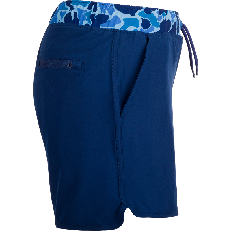 A versatile blue shorts with a camo print, featuring a 5 inseam and built-in liner for comfort. Made with quick-drying, moisture-wicking fabric and a durable water-resistant finish. Includes front and back pockets with hidden zippers. Perfect for playground or beach wear.