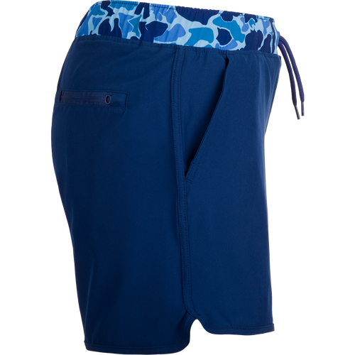 A versatile blue shorts with a camo print, featuring a 5 inseam and built-in liner for comfort. Made with quick-drying, moisture-wicking fabric and a durable water-resistant finish. Includes front and back pockets with hidden zippers. Perfect for playground or beach wear.
