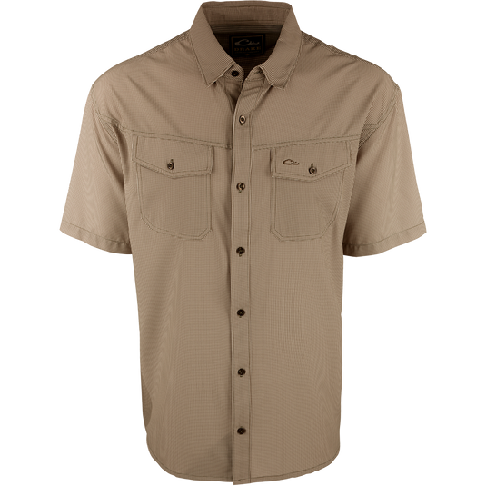 A brown checkered shirt with a four-way stretch fabric, moisture-wicking, and two chest pockets with button flaps. Traveler's Check Shirt S/S from Drake Waterfowl.